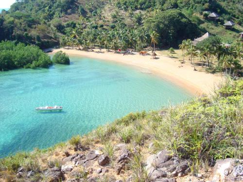 un bateau dans l'eau à côté d'une plage dans l'établissement Hotel Océan Beach Sakatia, à Nosy Be