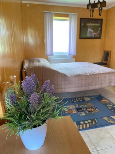 una camera con letto e tavolo con fiori viola di Constancia a Kam"janec'-Podil's'kyj