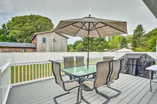 une table et des chaises sur une terrasse avec un parasol dans l'établissement Narragansett Escape by Narrow River and Beaches, à Narragansett