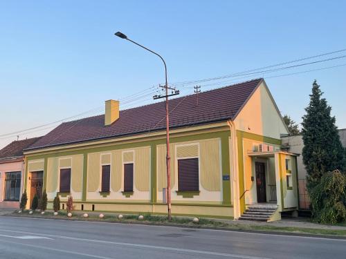 um edifício amarelo e branco ao lado de uma rua em PB Urban Garden Stay with secured Parking em Sremska Mitrovica