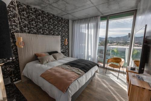 ein Schlafzimmer mit einem großen Bett und einem großen Fenster in der Unterkunft VILLA ALBA ROSULA in Ajaccio