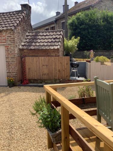 een tuin met een houten bank en een hek bij La Fagnoul in Ferrières