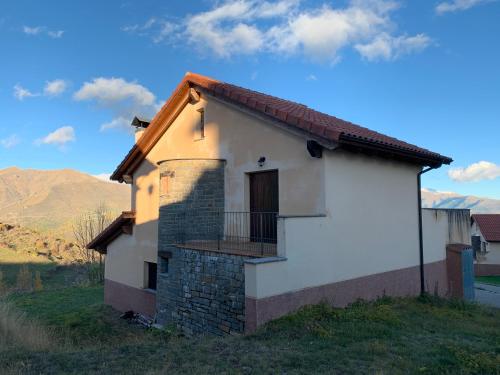 a small white house with a balcony on a hill at Chalet en el Pirineo de Aragón in Neril