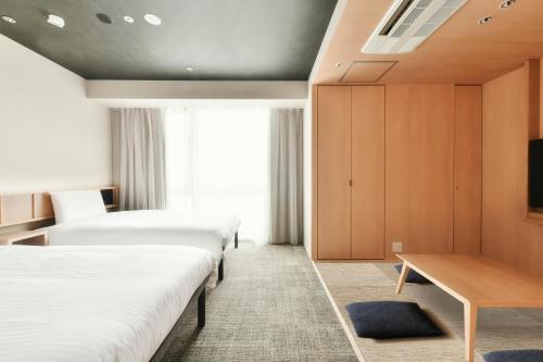 A bed or beds in a room at REF Matsuyama City Station by VESSEL HOTELS