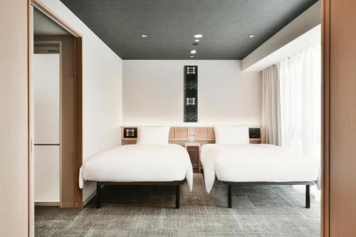 A bed or beds in a room at REF Matsuyama City Station by VESSEL HOTELS