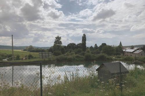 een waterlichaam met een hek ervoor bij Au bord du Ny in Hotton