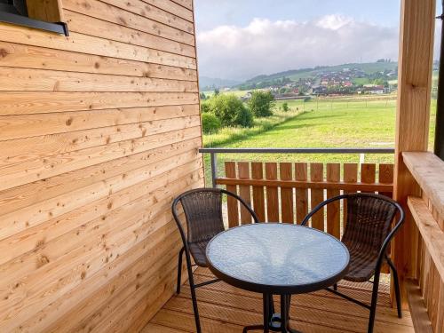 a table and two chairs on a balcony with a view at Sport HOTEL Bečva in Valašské Meziříčí