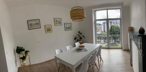 a white dining room with a white table and chairs at Au bord de l'Ourthe in La Roche-en-Ardenne