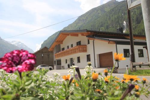 Un edificio con un mazzo di fiori davanti di Apart Bergglück a Sankt Leonhard im Pitztal