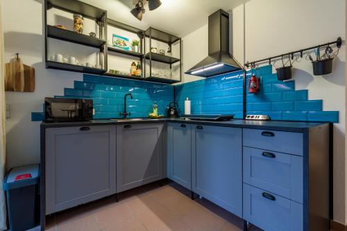 una cocina azul con azulejos azules en la pared en Ruhiges Apartment Ettlingen, en Ettlingen