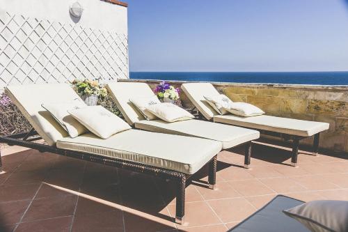 3 tumbonas en un patio con vistas al océano en B&B Relais Del Senatore, en Polignano a Mare