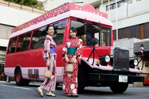 two women standing in front of a red and white van at Dogo Prince Hotel in Matsuyama