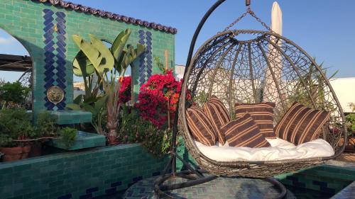 een hangstoel met kussens op een patio bij Riad Marhaba in Rabat