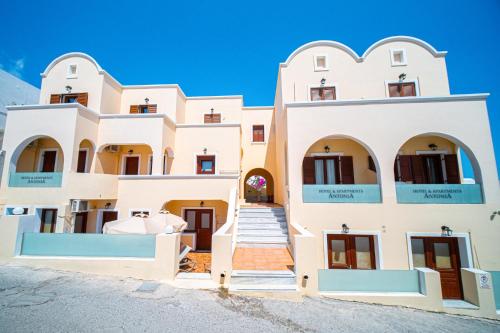 un grande edificio bianco con finestre ad arco e scale di Antonia Apartments a Firà