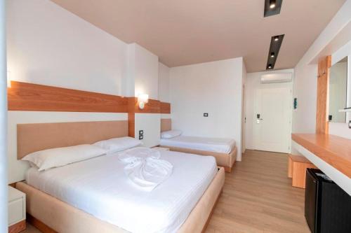 een hotelkamer met 2 bedden en een keuken bij Ventus Hotel in Ksamil