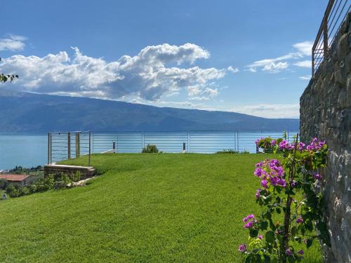 - une vue sur l'eau depuis une maison fleurie dans l'établissement Relais Zenner, à Toscolano Maderno