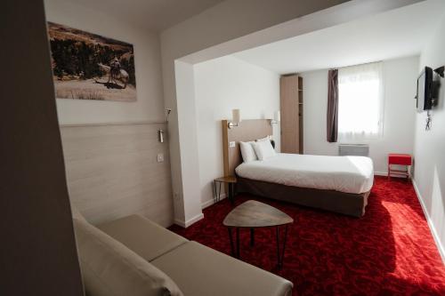 Habitación de hotel con cama y sofá en Kyriad Cholet, en Cholet