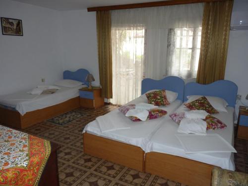 a hotel room with two beds and a window at Guest House Zhelevi in Sozopol