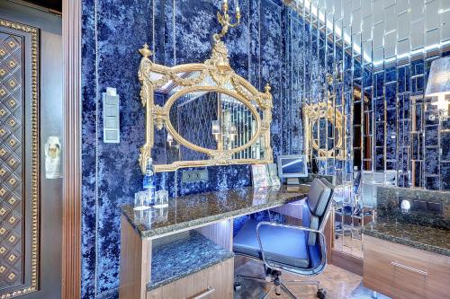 einen Salon mit blauen Wänden und einem goldenen Spiegel in der Unterkunft Mała Anglia Deluxe Rooms & SPA in Sopot