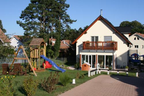 une maison avec une aire de jeux en face dans l'établissement BnB "Les Coquelicots", à Mies