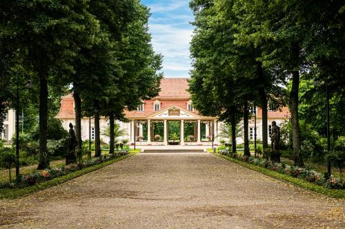 une allée menant à une grande maison arborée dans l'établissement Hotel Kurhaus Bad Bocklet, à Bad Bocklet