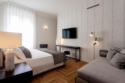 pokój hotelowy z łóżkiem i kanapą w obiekcie Apollo Suite w Syrakuzach