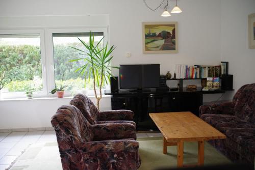 een woonkamer met 2 stoelen, een tafel en een tv bij Ferienwohnung Schuur - Buchholz in der Nordheide in Buchholz in der Nordheide