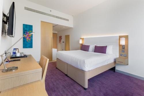 1 dormitorio con 1 cama y escritorio con ordenador en Premier Inn Dubai Ibn Battuta Mall, en Dubái