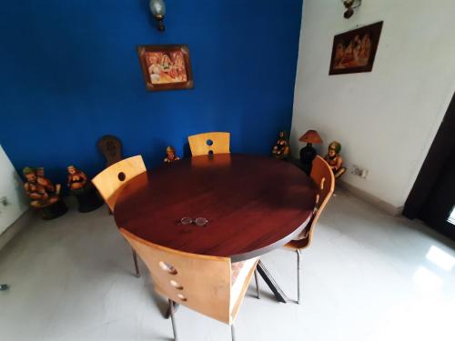 een houten tafel en stoelen in een kamer bij Grace Home in New Delhi