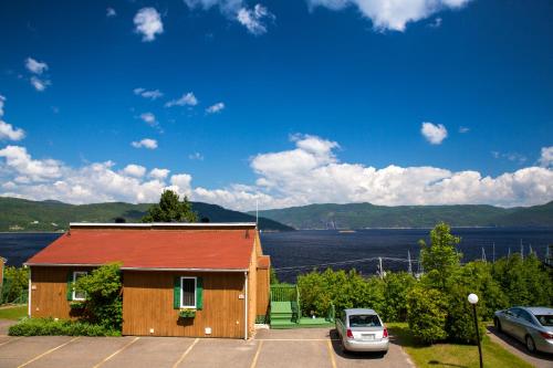 um edifício com um carro estacionado num parque de estacionamento em Chalets Condos sur le Fjord em LʼAnse-Saint-Jean