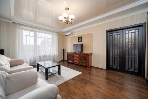 Lux Apartment Gorkiy Park في خاركوف: غرفة معيشة مع أريكة بيضاء وطاولة