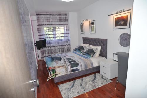 a bedroom with a bed and a window at Twins Apartments in Čačak