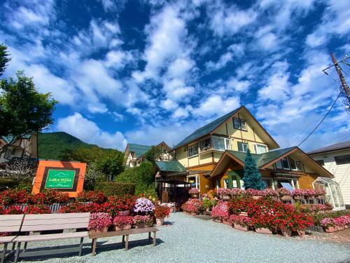 een huis met bloemen ervoor bij Lake Villa Kawaguchiko in Fujikawaguchiko