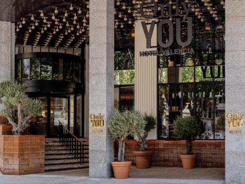 un magasin devant un bâtiment avec des plantes en pots dans l'établissement Only YOU Hotel Valencia, à Valence