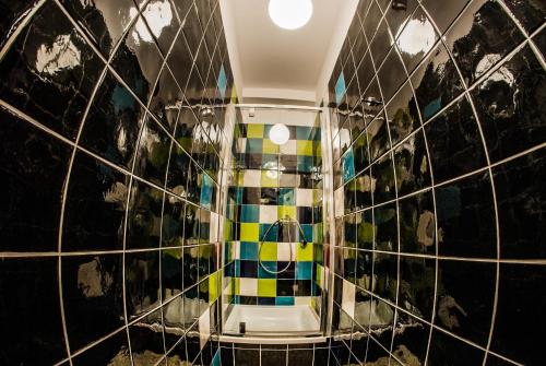 a bathroom with a shower with colorful tiles at Atlantis Hostel in Kraków