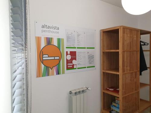 una pared con un cartel y un estante para libros en Altavista Penthouse T2, en Covilhã