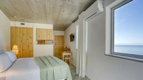 een slaapkamer met een bed en een groot raam bij Socalco Nature Calheta in Calheta