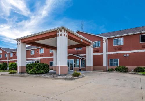 Rodeway Inn Urbana Champaign University Area في شامبين: مبنى أحمر كبير مع موقف للسيارات