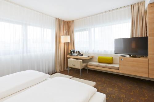 Tempat tidur dalam kamar di H+ Hotel Salzburg