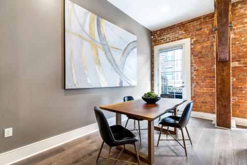 a dining room with a wooden table and chairs at The Calliope in New Orleans