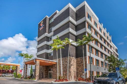 un bâtiment avec des palmiers en face de celui-ci dans l'établissement Comfort Suites Fort Lauderdale Airport & Cruise Port, à Dania Beach