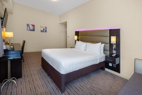 Habitación de hotel con cama grande y escritorio. en Premier Inn Dubai Ibn Battuta Mall, en Dubái