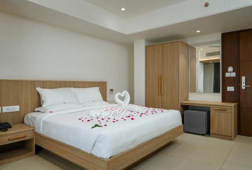 Un dormitorio con una cama blanca con rosas. en The Trios Hotel, en Kochi