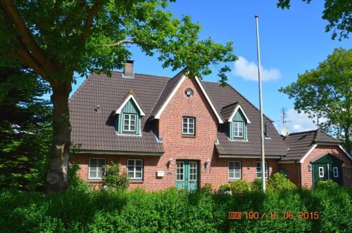 una casa de ladrillo rojo con techo de gambrel en Greggersen - Whg 1, en Nieblum