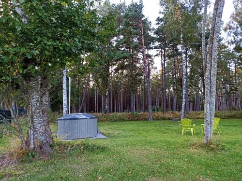 una mesa de picnic y sillas en un parque con árboles en Mežalauki, en Kolka