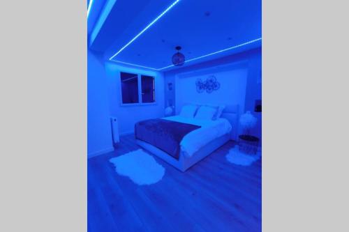 a blue bedroom with a bed and a couch at Nid d'amour baignoire/jacuzzi in Nice