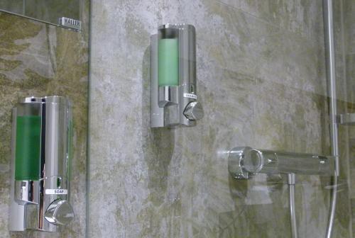 um chuveiro com uma porta de vidro com um objecto verde em Hotel Grüne Elster em Fürth