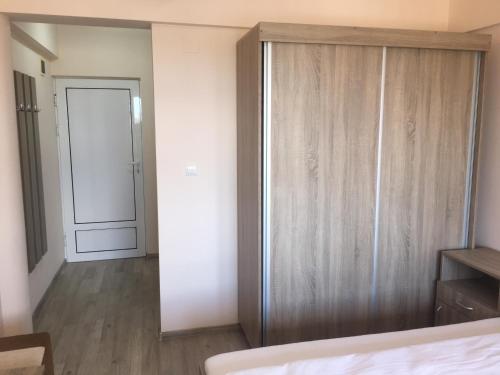 - une chambre avec un grand placard en bois et une porte dans l'établissement Cazare Hofmann, à Arad