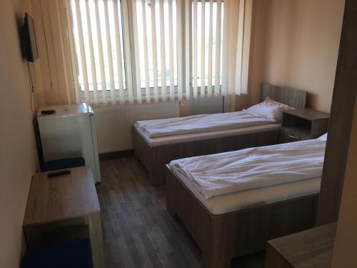 Cette petite chambre comprend 2 lits et une fenêtre. dans l'établissement Cazare Hofmann, à Arad