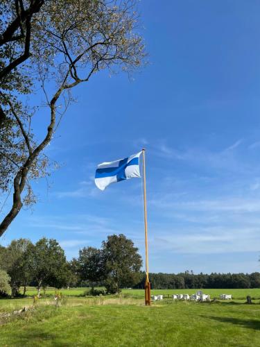 un drapeau bleu et blanc sur un pôle dans un champ dans l'établissement Villa BlauwHemel Diever, à Diever